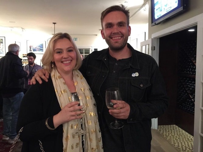 Christopher Candy and his sister Jennifer Candy are holding glasses of wines 